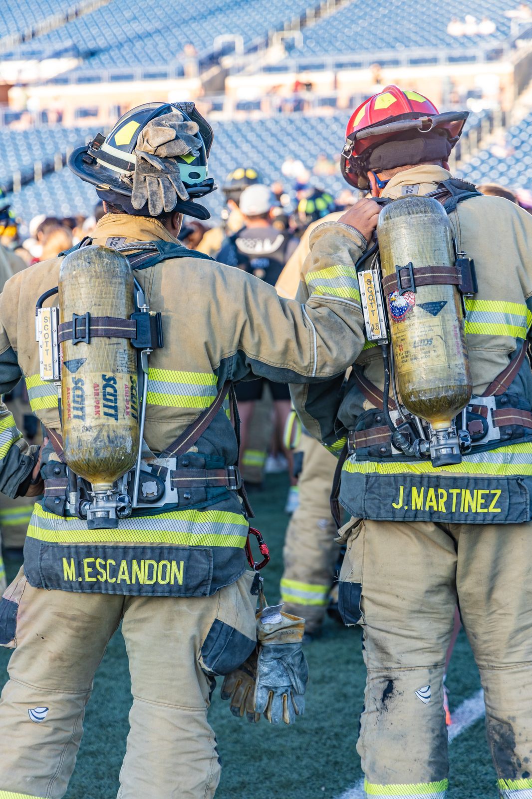 Two firefighters in full gear with names on their coats