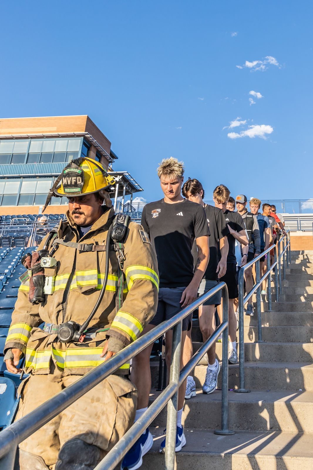 Firefighters in full gear climbing stadium stairs