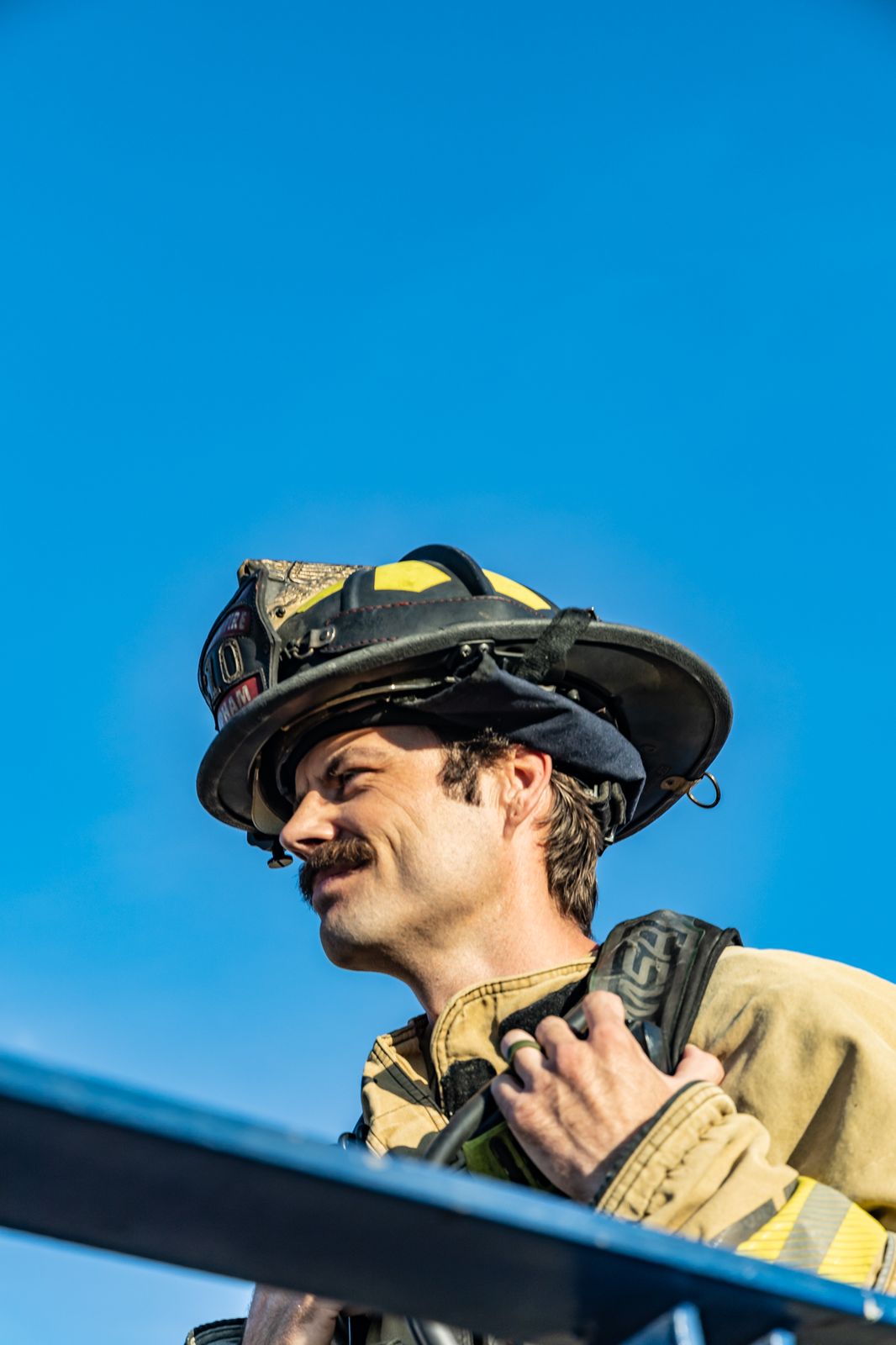 Firefighter in helmet against a blue sky