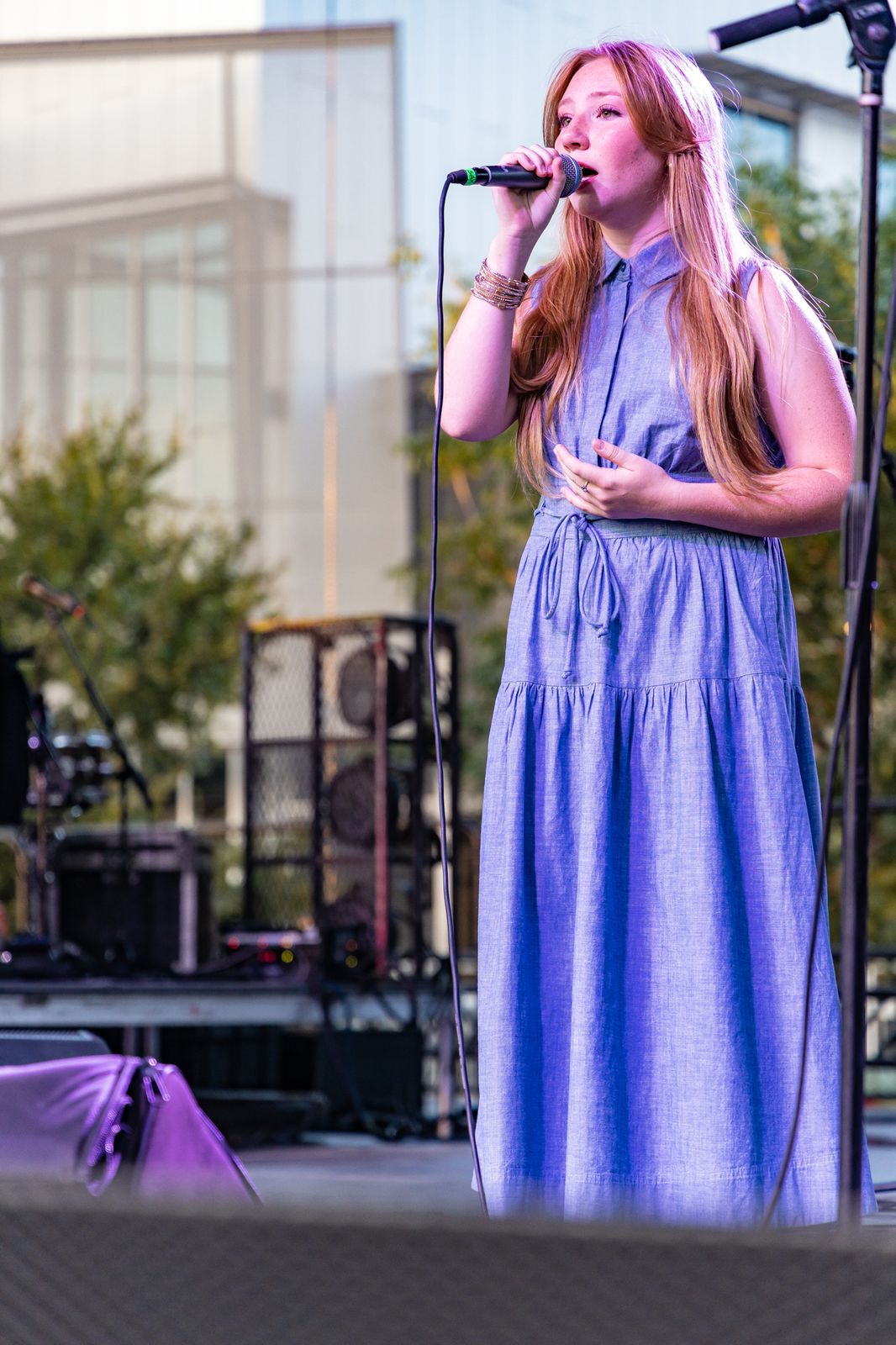 Singer in a blue dress performing on stage